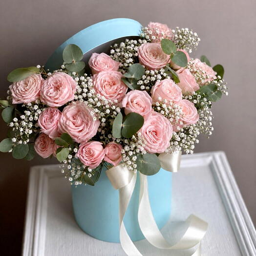 A flower box in a delicate mint color, filled with peony roses.